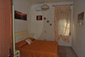 a small bedroom with a bed and a window at Appartamento Vacanza in Mògoro