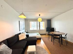 a living room with a couch and a table at Warm and cozy one-bedroom & Sauna in Vantaa