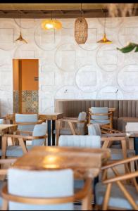 a dining room with wooden tables and chairs at Oasis Apart-Hotel Residence Vlore in Vlorë