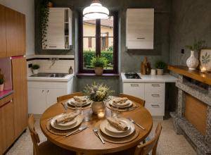 a kitchen with a wooden table with plates on it at Ortensia Apartment for 4 near Lake Como and Lugano in Lanzo dʼIntelvi