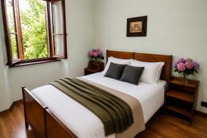 a bedroom with a large bed with two windows at Ortensia Apartment for 4 near Lake Como and Lugano in Lanzo dʼIntelvi
