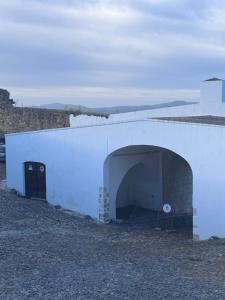 a white building with a tunnel in the side of it at Casa das Portas de Évora in Estremoz