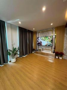 ein großes Wohnzimmer mit großem Fenster und Holzböden in der Unterkunft Villa996 in Ban Bang Pi