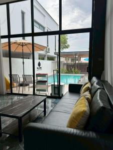 ein Wohnzimmer mit Sofa, Tisch und Pool in der Unterkunft Villa996 in Ban Bang Pi