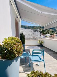 a patio with two chairs and a table on a balcony at Dimora del Corso - Rooms in Mattinata
