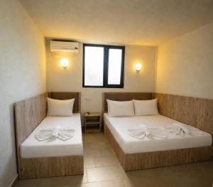 a room with two beds with bows on them at Complex Vraja Mării Costinești in Costinesti +103 photos