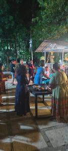 a group of people sitting at a picnic table at Harshangi Resort wada in Wada