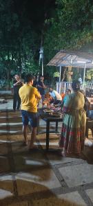 a group of people standing around a picnic table at Harshangi Resort wada in Wada
