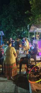 a group of people sitting at a picnic table at Harshangi Resort wada in Wada