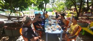a group of people sitting around a table at Harshangi Resort wada in Wada
