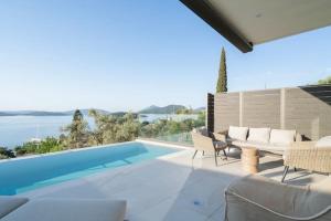 a swimming pool with chairs and a table next to a swimming pool at Villa Incanto in Nydri