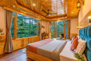 a bedroom with a bed and a large window at Getaway Stays Manali in Manāli