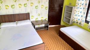 a small bedroom with two beds and a table at Two in One Restaurant & Lodge in Pokhara