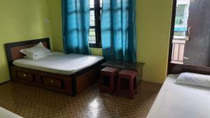 a small room with two beds and a window at Two in One Restaurant & Lodge in Pokhara