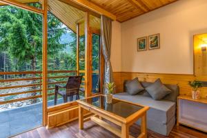 a living room with a couch and a table at Getaway Stays Manali in Manāli