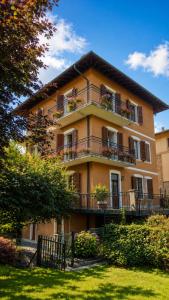 a large building with balconies and plants in a yard at Ortensia Apartment for 4 near Lake Como and Lugano in Lanzo dʼIntelvi +46 photos