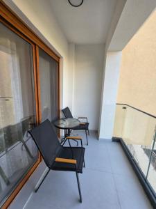 a balcony with two chairs and a table and a window at Eclipse Luxury Suite in Šušanj