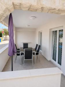 a dining room with a table and chairs and an umbrella at Apartments Adria in Vir +35 photos