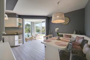 a kitchen and living room with a table and a couch at Chillout House with heated pool 29 C Sea & Mountain view in Santa Susanna
