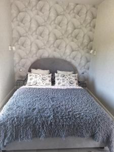 a bedroom with a large bed with a tufted headboard at Domek Za Wyspą 1 in Chmielów
