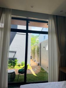 a bedroom with a window looking out at a yard at Wind Village in Hà Lời +16 photos