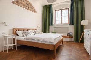 a bedroom with a large bed with green curtains at Vlaštovčí dům in Nové Město nad Metují