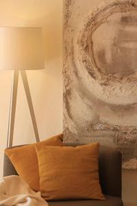 a couch with a pillow next to a lamp at Alegria Studios - en Provence - Piscine avec vue - Terrasse privative in Aups