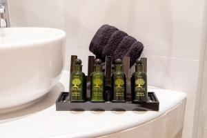 a group of four bottles of alcohol on a bathroom counter at Gaia Trikeri Suites in Ayía Kiriakí