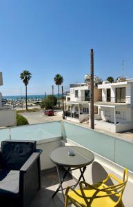 a patio with chairs and a table on a balcony at Relax Beach Apartment in Larnaca