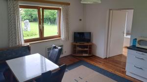 a dining room with a table and a television at Ferienwohnungen Benedikt in Villach