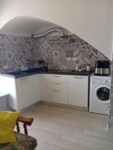 a kitchen with a sink and a washing machine at Casa di nonna Caterina in Nemoli