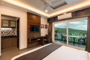 a hotel room with a large window and a television at Hotel Altitude Coorg in Madikeri +63 photos