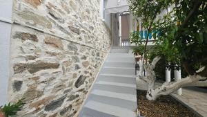 a stone wall with a staircase next to a building at Olive Garden Estate in Elevtheraí
