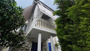 a white house with a balcony and trees at Olive Garden Estate in Elevtheraí +27 photos