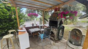 a patio with an old wood stove and a table at Olive Garden Estate in Elevtheraí