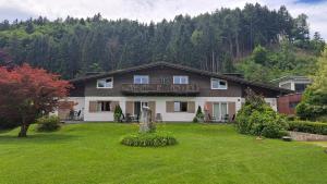 a large house with a yard with a house at Ferienwohnungen Benedikt in Villach