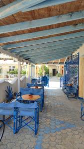 a group of blue chairs and tables on a patio at Cosmos Studios in Olympic Beach