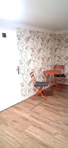 a room with two chairs and a table and a wall at Logement entier RDC quartier historique Parthenay in Parthenay