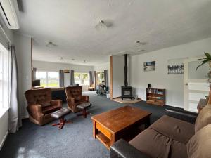 a living room with a couch and chairs and a table at Destination Cliff Top - Cottage and Homestead in Ohingaiti