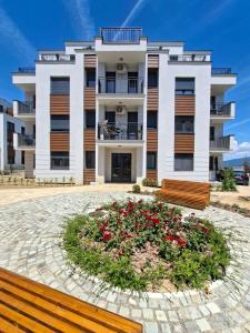 a building with a circle of flowers in front of it at Apartman Merry Lux in Vrnjačka Banja