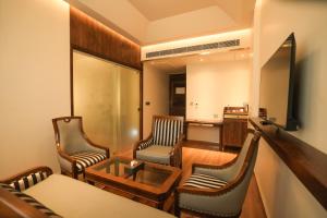 a living room with two chairs and a table at raj Regent kurichy in Putuppalli