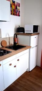 a kitchen with white cabinets and a microwave at Logement entier RDC quartier historique Parthenay in Parthenay +6 photos