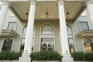 a large building with white columns at raj Regent kurichy in Putuppalli