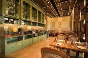 a restaurant with green cabinets and tables and chairs at raj Regent kurichy in Putuppalli