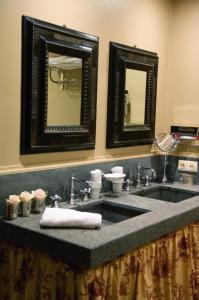 a bathroom with a sink and two mirrors at B&B Exclusive Guesthouse Bonifacius in Bruges