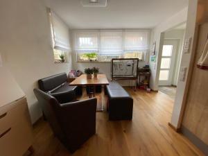a living room with a table and leather chairs at Schöne 2-Zimmer-Souterrainwohnung mit Terrasse in Offenburg