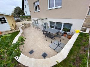 a patio with a table and chairs in front of a house at Schöne 2-Zimmer-Souterrainwohnung mit Terrasse in Offenburg