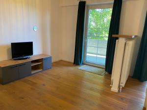 a living room with a tv and a large window at Pension Straßl in Andorf