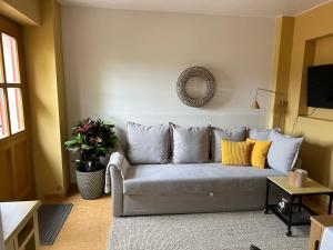 a living room with a gray couch with yellow pillows at Fuchsbau-eine Auszeit für die Seele in Kritzmow