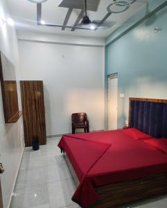 a bedroom with a red bed and a chair at Vijay Villa in Faizābād +5 photos